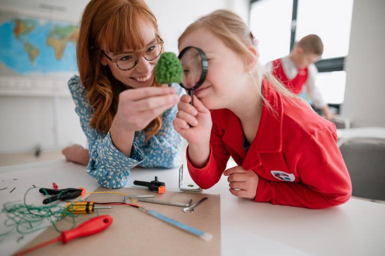 adult and child looking at magnifying glass