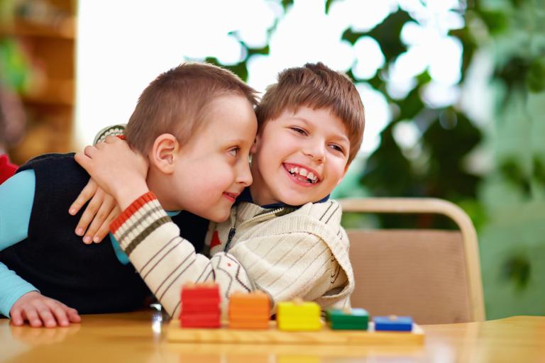children hugging, building blocks on table